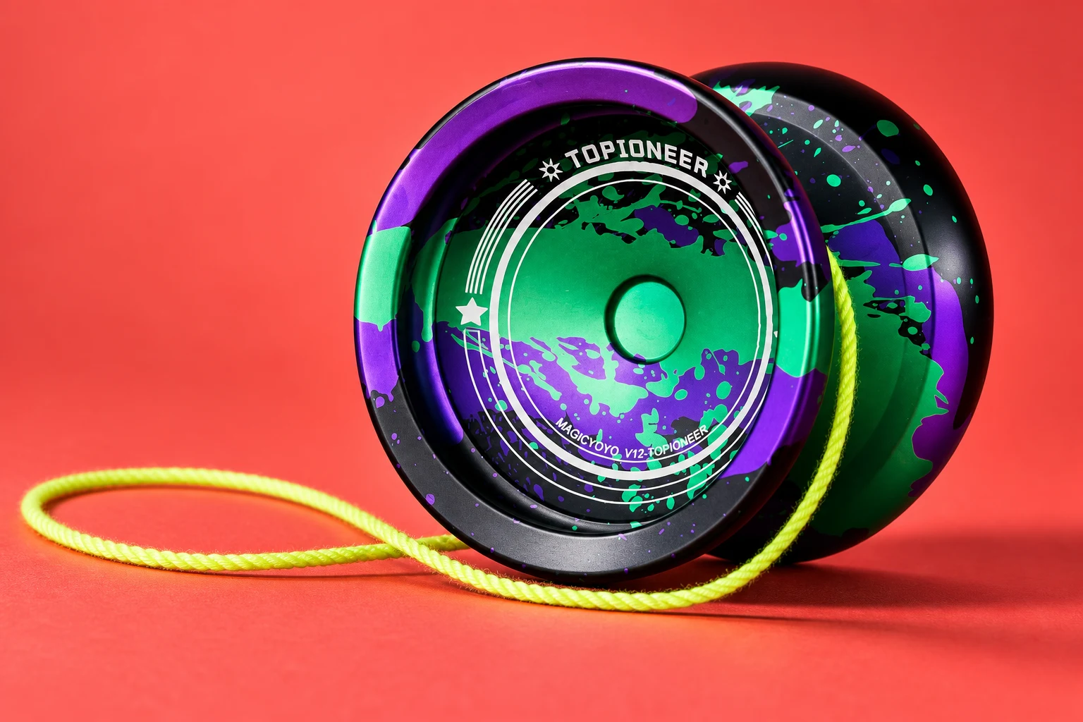 MAGICYOYO V12 TOPIONEER in black, green and purple with a lime string on a coral surface